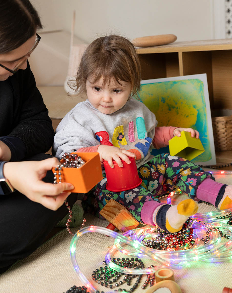 Shania playing with a young girl in the baby and toddler suite 