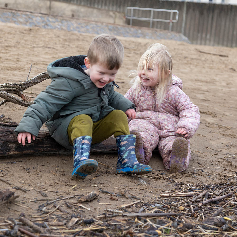 Two young children from playway nursery playing on the beach