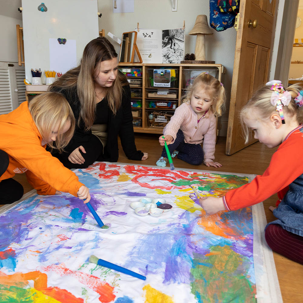 Children painting with the staff at playway nursery 